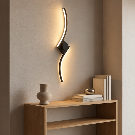 Gold S-curve wall light casting a soft glow on a bare wall