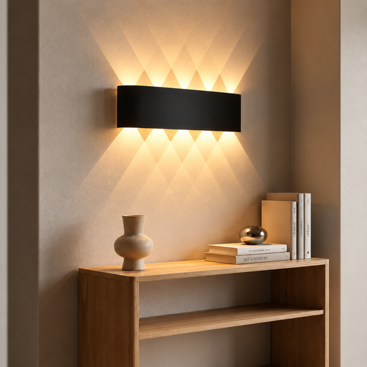 Black cordless wall sconce casting light up and down above a console table